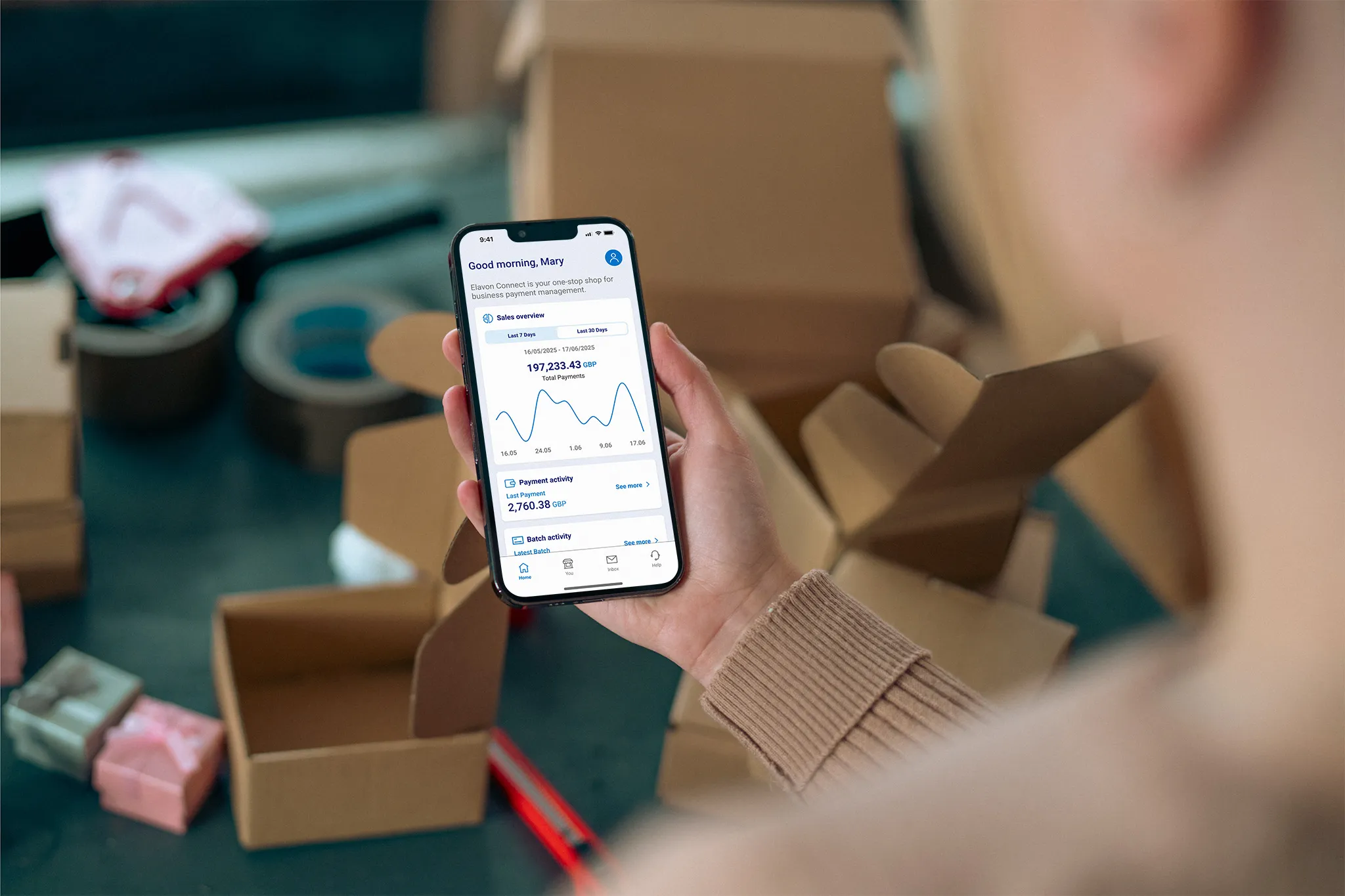 person hält smartphone mit business app und statistiken in verpackungsbereich